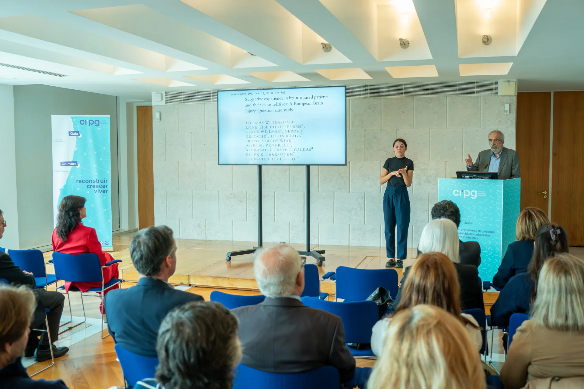Plateia assiste ao discurso do Neurologista e Professor Catedrático Jubilado – Alexandre Castro Caldas. O discurso é acompanhado com uma apresentação no ecrã que se encontra no palco principal.