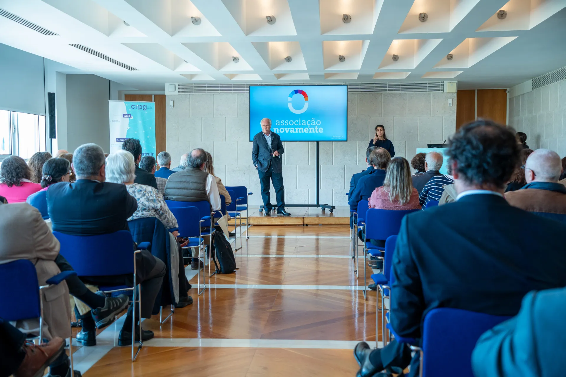 Corredor com plateia a assistir ao discurso do Vogal da Direção da Associação Novamente – Luiz Godinho Lopes