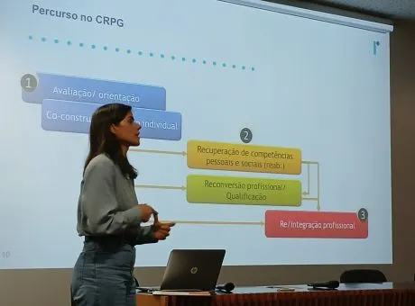 fotografia de pessoa a falar com projeção de apresentação na parede