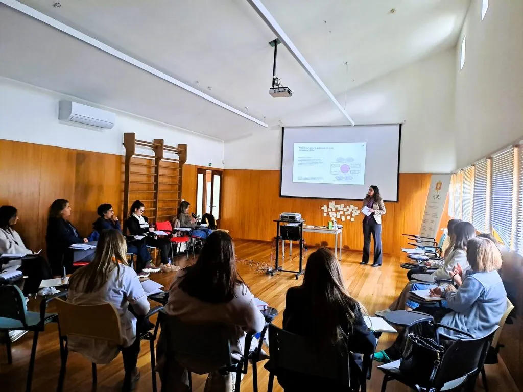 20250317_154446 Fotografia de pessoas sentadas a assistir a apresentação de orador com a apresentação a ser projetada na tela