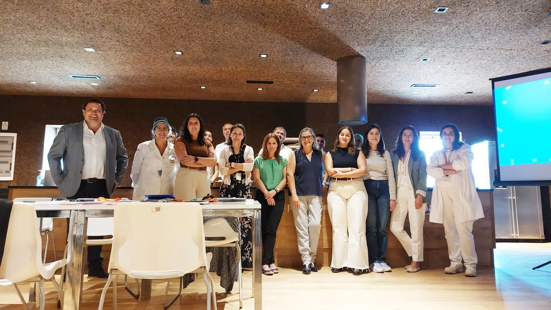 20251014_161749b Fotografia de pessoas lado a lado, a sorrirem com apresentação projetada atrás