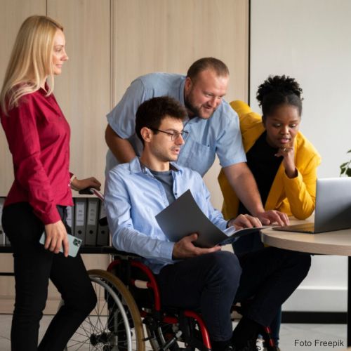 Ações à medida Quatro pessoas reunidas a olhar para o computador