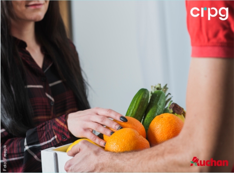 fotografia de pessoa com uma caixa na mão a entregar a outra com o logotipo Auchan e CRPG