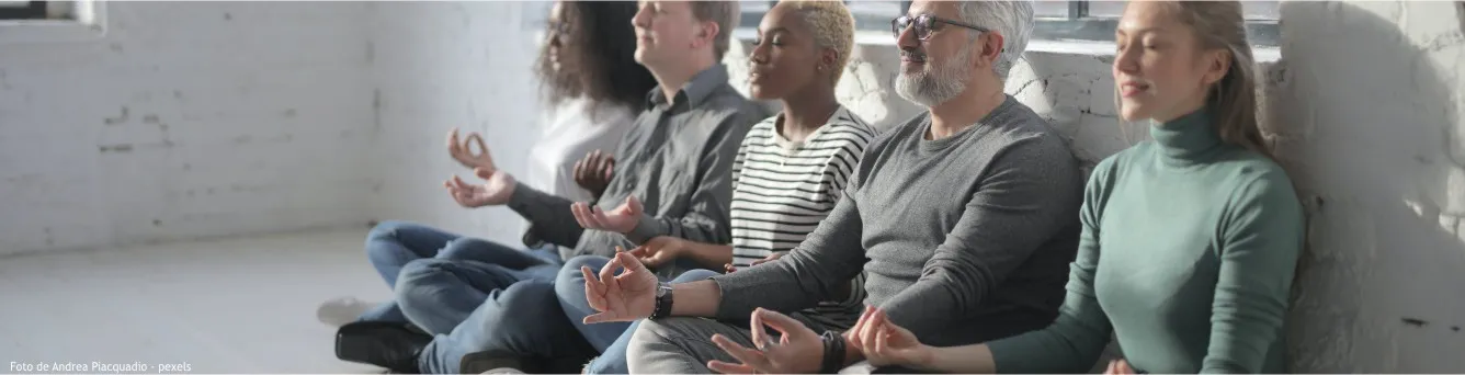 pessoas sentadas com pernas cruzadas a meditar