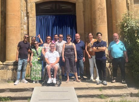 grupo de clientes lado a lado a olhar para a fotografia à porta da Fábrica das sombras