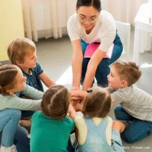 Imagem de cuidador rodeado de crianças