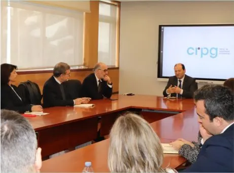 fotografia de pessoas sentadas à mesa a conversar