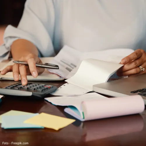 pessoa a fazer contas numa máquina calculadora