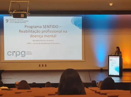 Fotografia de técnica do CRPG no púlpito durante a sua apresentação. E imagem da apresentação projetada na tela.
