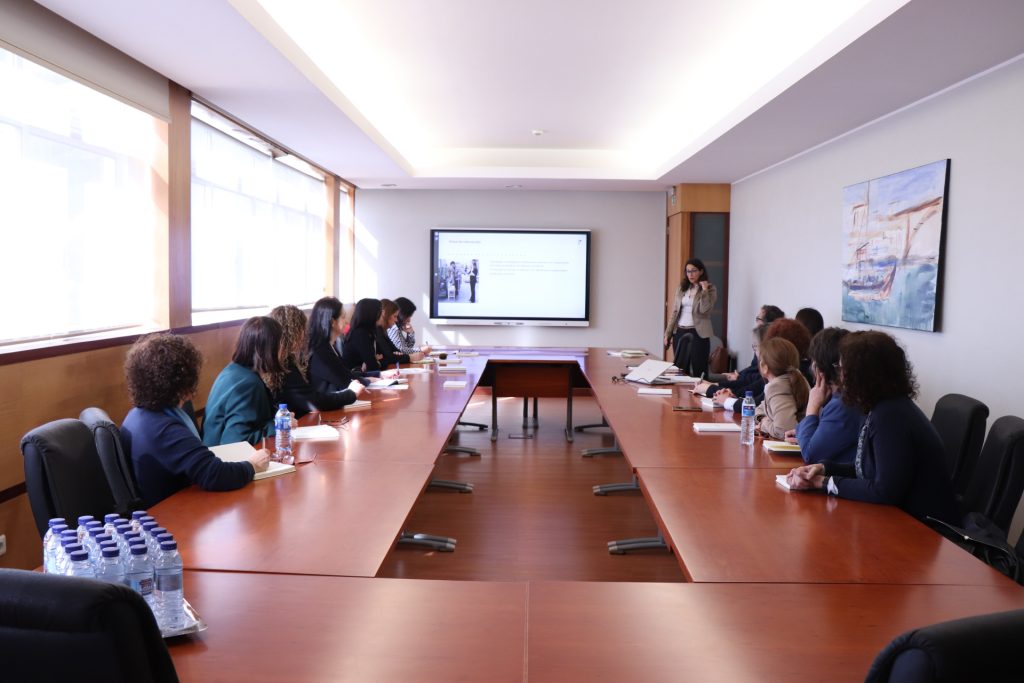 fotografia de pessoas sentadas à mesa a assistir a uma apresentação