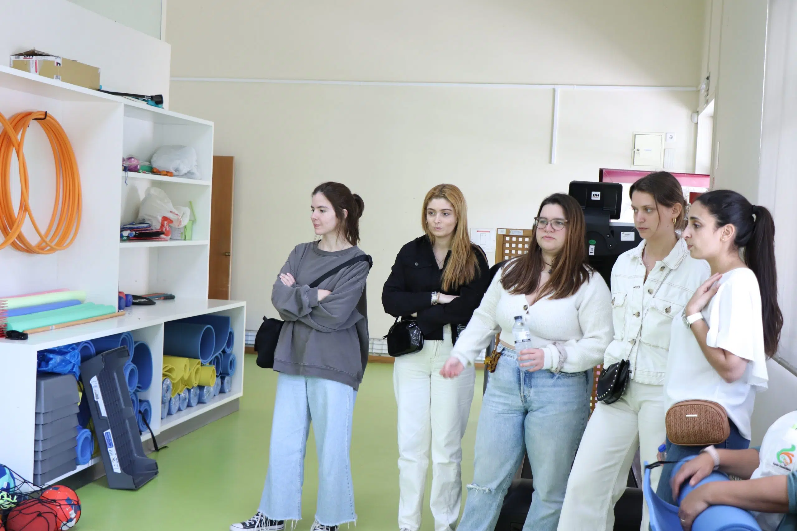 alunos em pé a assistirem a uma explicação sobre a atividade a decorrer na mesma sala