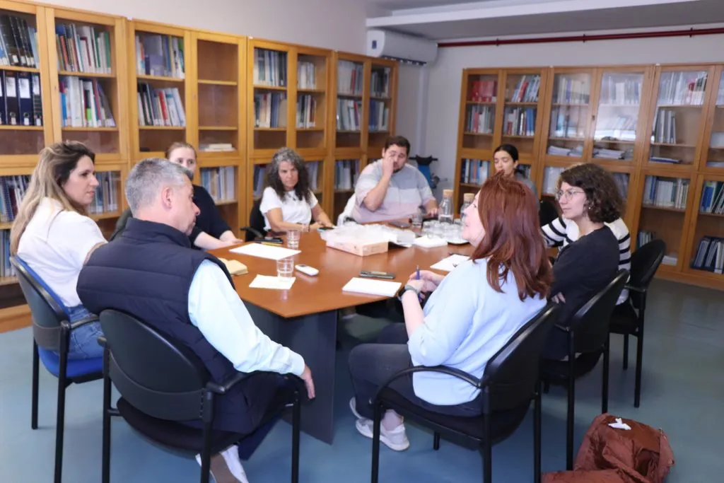 9 pessoas à mesa durante reunião