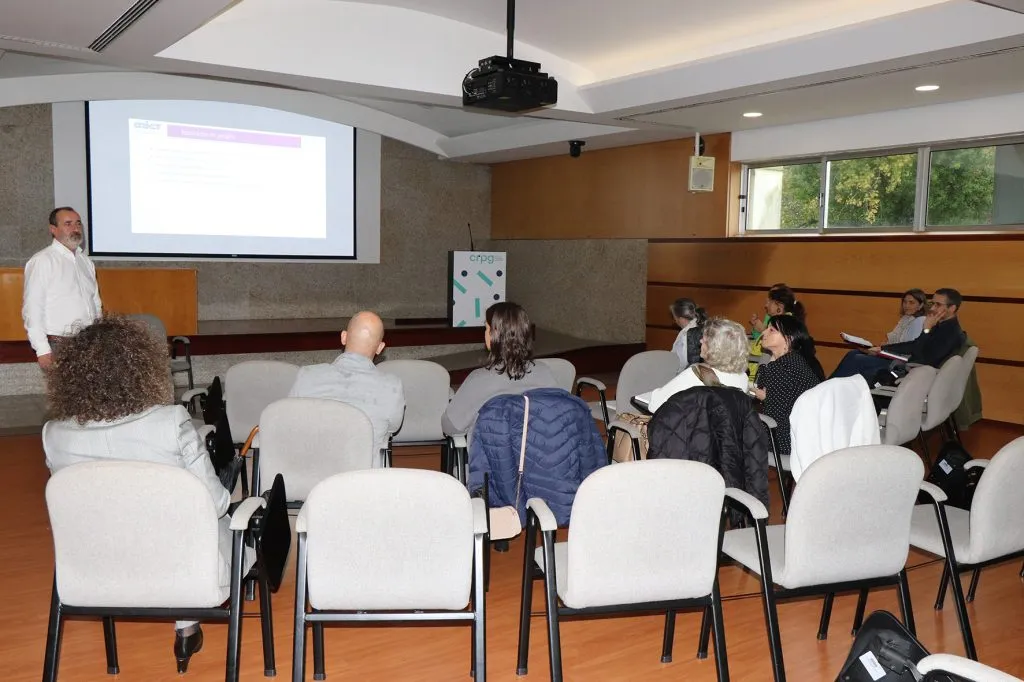 fotografia de participantes sentados a assistir a apresentação