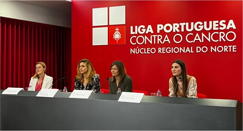 quatro pessoas numa mesa virada para público durante uma conferência