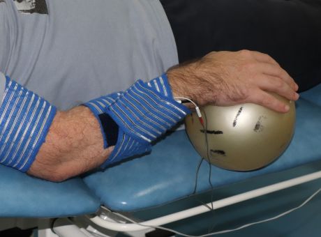 braço elevado com mão numa bola