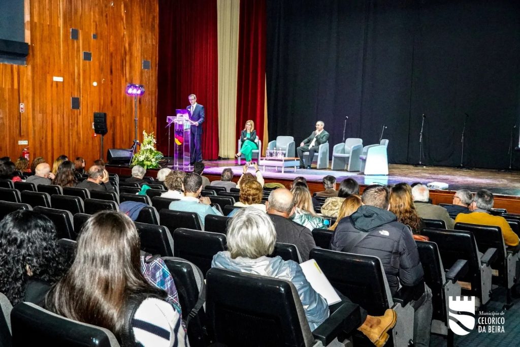 fotografia do auditório com pessoas sentadas a assistir ao orador