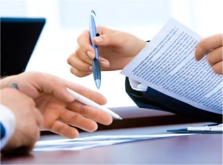 caneta na mão e documento na outra mão