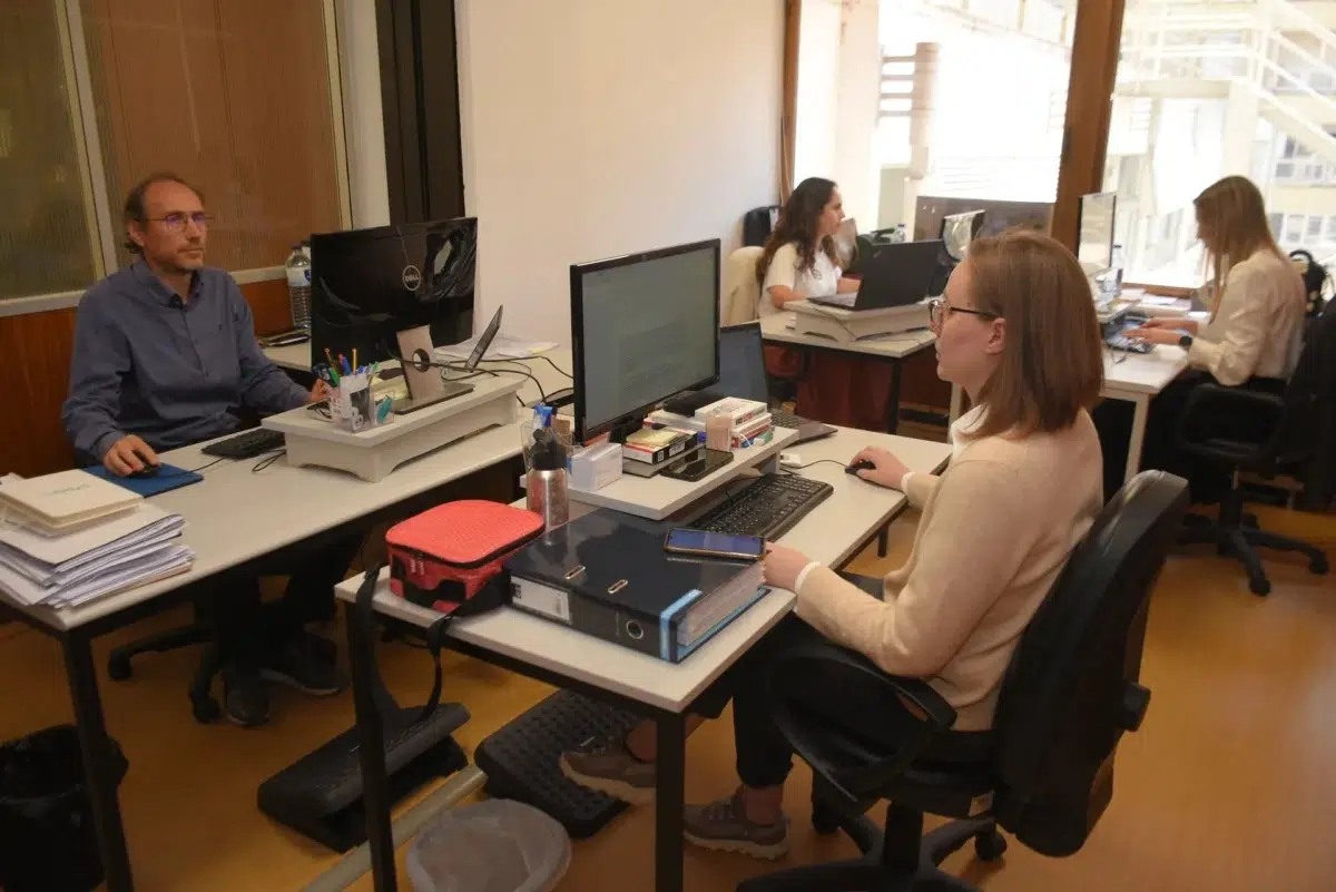 CRPG - Centro de Reabilitação Profissional. Delegação de Coimbra Fotografia de colaboradores sentados, cada uma na sua secretária a trabalhar