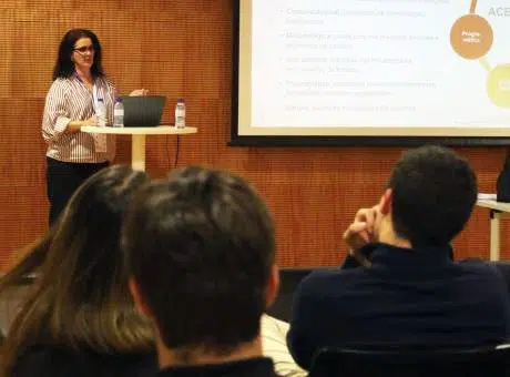 Mulher, em pé, num placo, durante apresentação