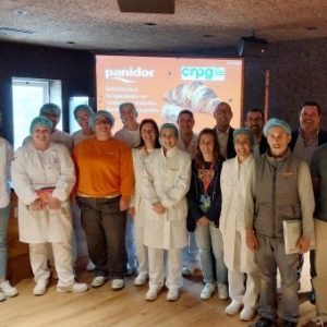 Fotografia de pessoas lado a lado, a sorrirem com apresentação projetada atrás