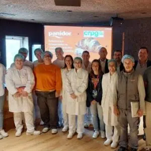 Fotografia de pessoas lado a lado, a sorrirem com apresentação projetada atrás