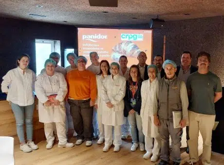 Fotografia de pessoas lado a lado, a sorrirem com apresentação projetada atrás