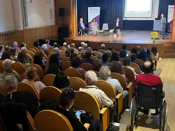fotografia de pessoas a assistir a apresentação em auditório