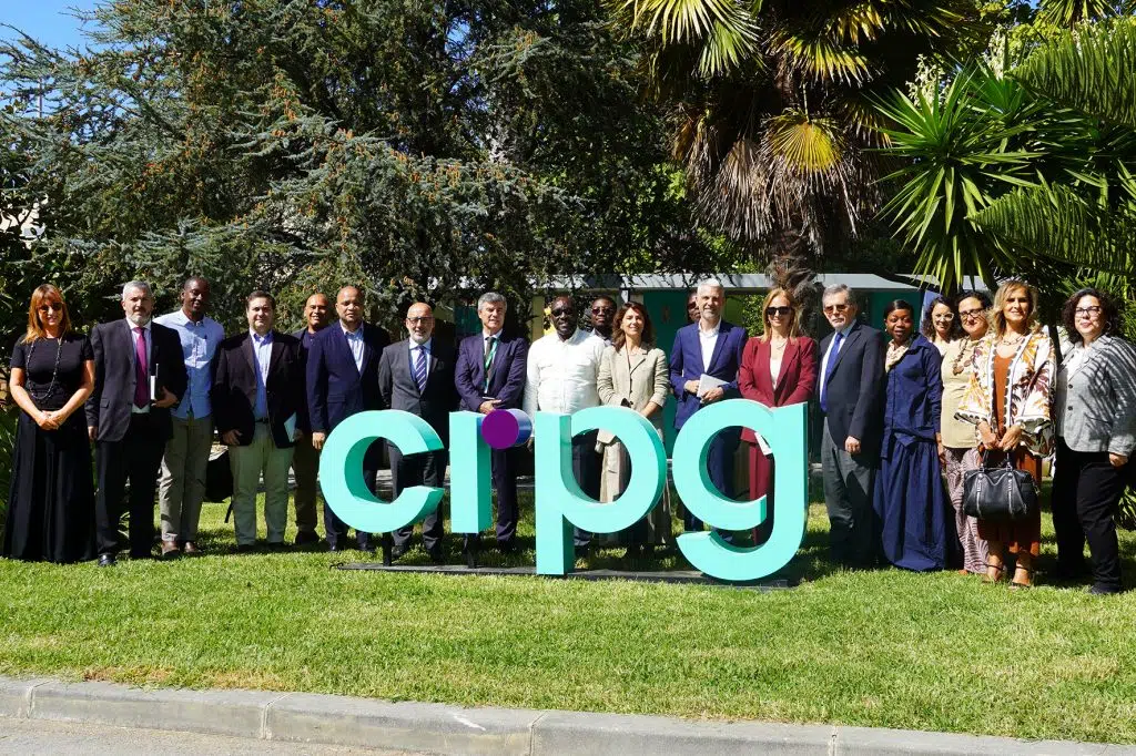 Foto grupo de pessoas lado a lado a sorrirem com logotipo do CRPG no jardim