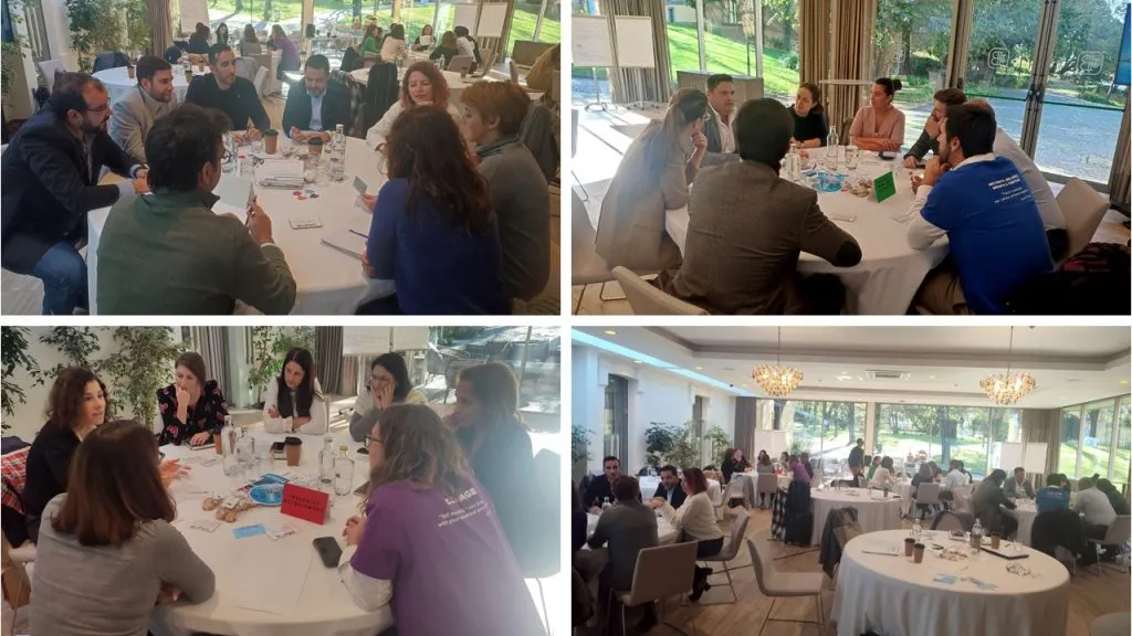 Fotografia de vários grupos de pessoas, em mesas circulares a conversar sobre Diversidade e Inclusão