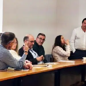 fotografia de José Oliveira, em pé, a escutar uma pessoa