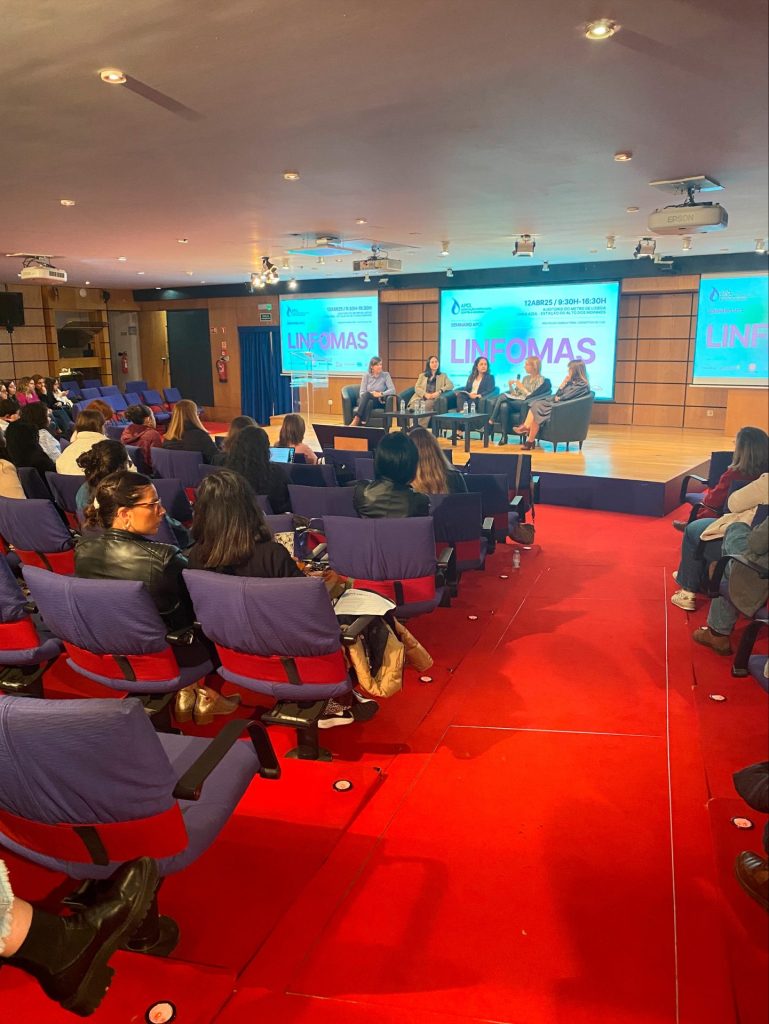 fotografia de pessoas sentadas a olhar para o palco enquanto decorre uma mesa redonda